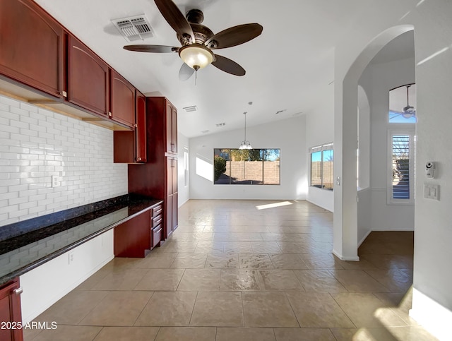 kitchen featuring lofted ceiling, backsplash, decorative light fixtures, and ceiling fan