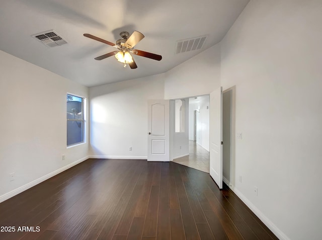 spare room with dark hardwood / wood-style flooring, vaulted ceiling, and ceiling fan