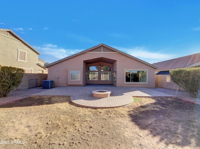 rear view of property featuring a patio area, central AC, and an outdoor fire pit