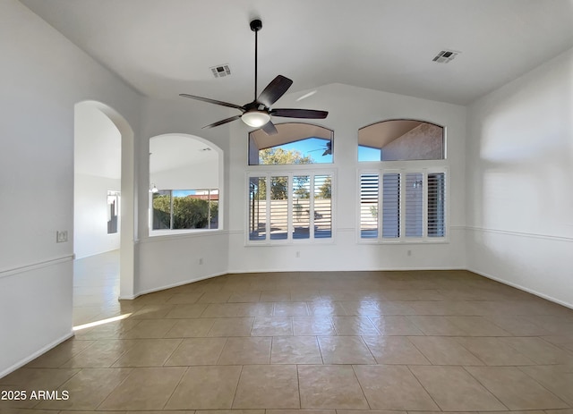 empty room featuring vaulted ceiling, light tile patterned floors, and ceiling fan