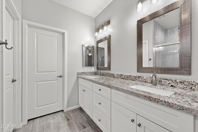 bathroom with a shower with door, vanity, and hardwood / wood-style flooring