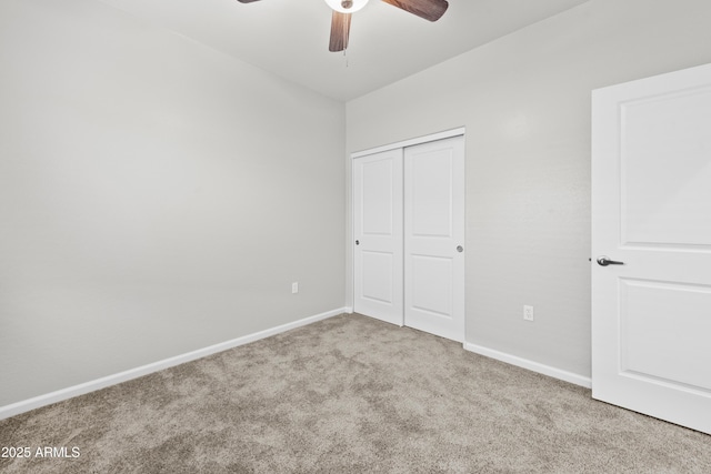 unfurnished bedroom featuring light colored carpet, ceiling fan, and a closet