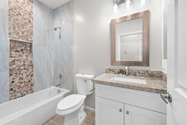 full bathroom with vanity, tiled shower / bath, and toilet