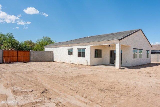 rear view of property with a patio and ceiling fan