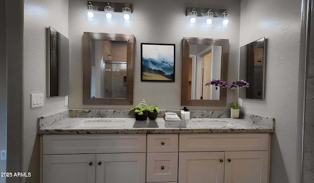 bathroom featuring a shower with door and vanity