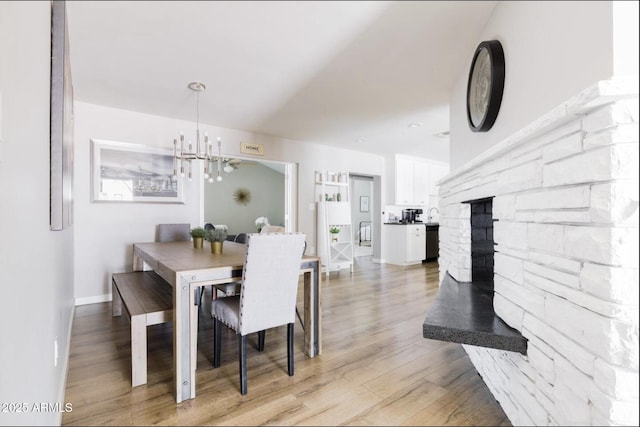 dining space with light hardwood / wood-style flooring and a chandelier