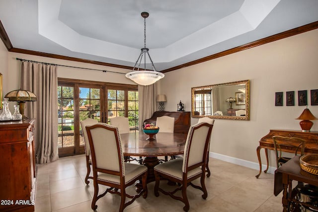 dining room with ornamental molding, a raised ceiling, and french doors