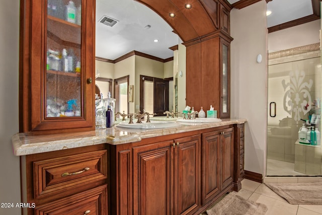 bathroom featuring ornamental molding, a shower with door, tile patterned flooring, and vanity