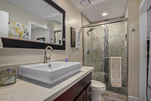 bathroom with vanity, an enclosed shower, and toilet