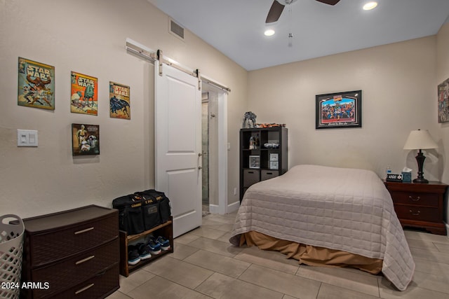 tiled bedroom featuring ceiling fan and a barn door