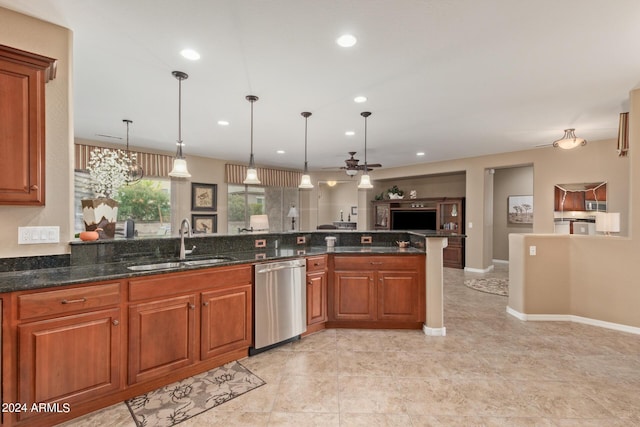 kitchen with sink, ceiling fan, hanging light fixtures, stainless steel dishwasher, and dark stone counters