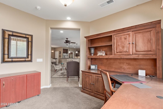 carpeted home office featuring ceiling fan