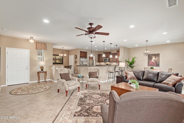 living room with ceiling fan with notable chandelier and light tile patterned floors