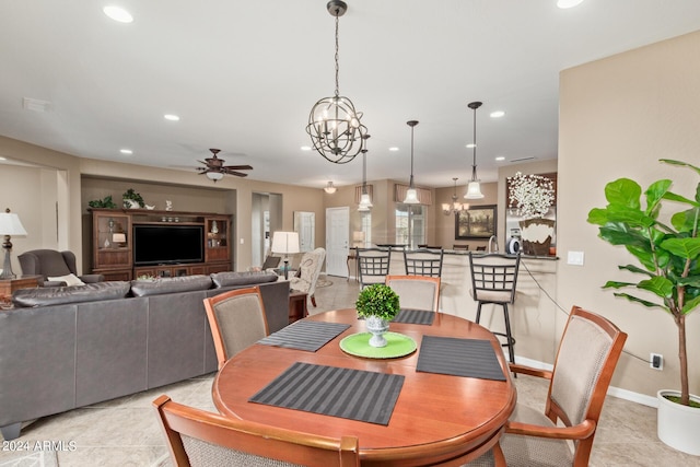 dining space with ceiling fan with notable chandelier