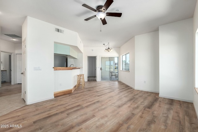 unfurnished living room with light wood-style floors, baseboards, and visible vents