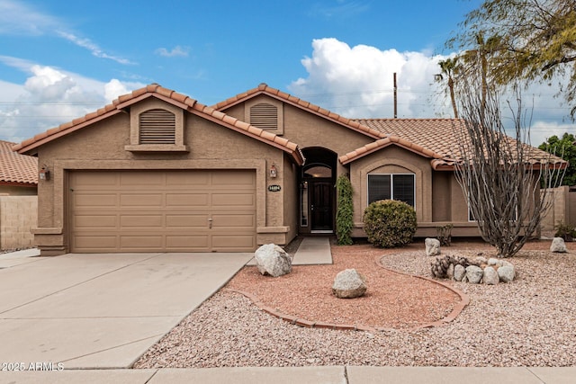 mediterranean / spanish-style home with concrete driveway, an attached garage, a tile roof, and stucco siding