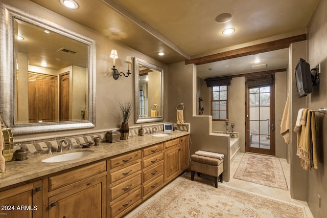 bathroom with dual vanity, tile patterned flooring, and a bath