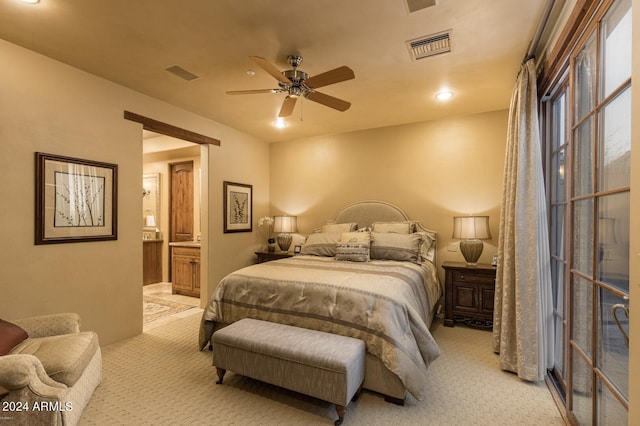 carpeted bedroom with ensuite bath and ceiling fan