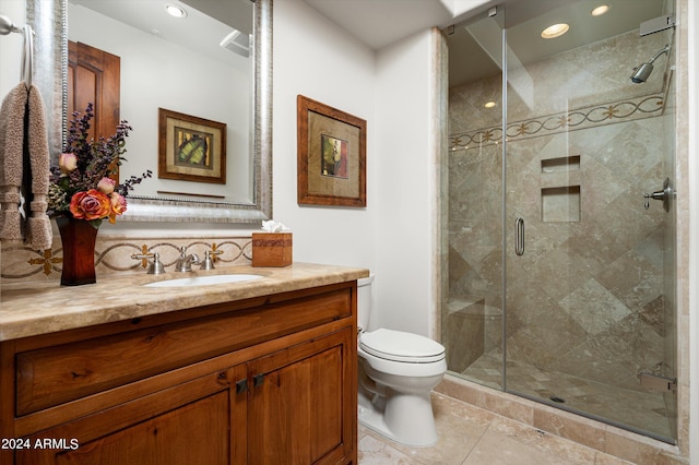 bathroom featuring tile patterned flooring, a shower with shower door, toilet, and vanity