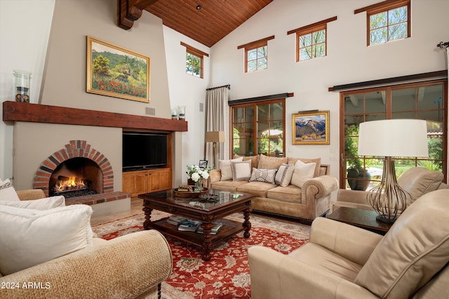 living room with wooden ceiling, a brick fireplace, high vaulted ceiling, and a healthy amount of sunlight