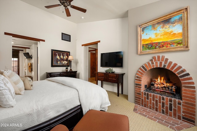 carpeted bedroom with a fireplace and ceiling fan