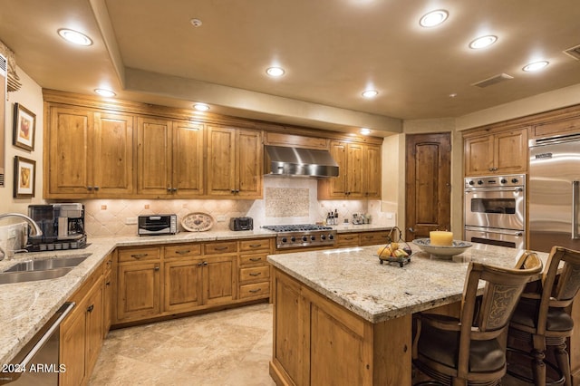 kitchen with light tile patterned flooring, a kitchen island, appliances with stainless steel finishes, wall chimney exhaust hood, and sink