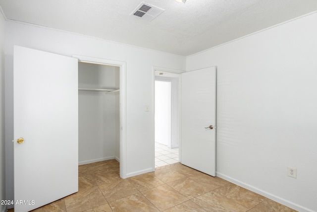 unfurnished bedroom with light tile patterned floors and a closet