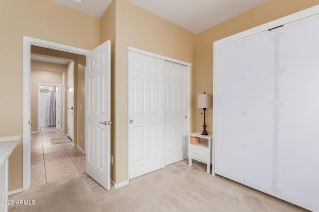 unfurnished bedroom with light colored carpet and a closet