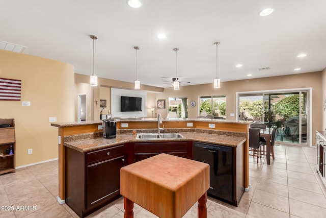 kitchen featuring sink, light tile patterned floors, an island with sink, and dishwasher