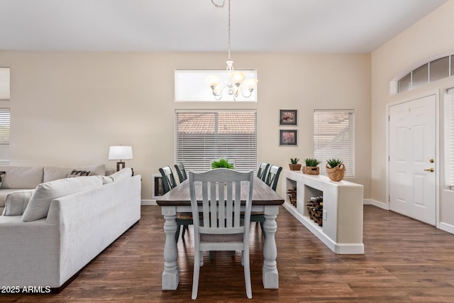 dining area with dark wood-type flooring and a chandelier