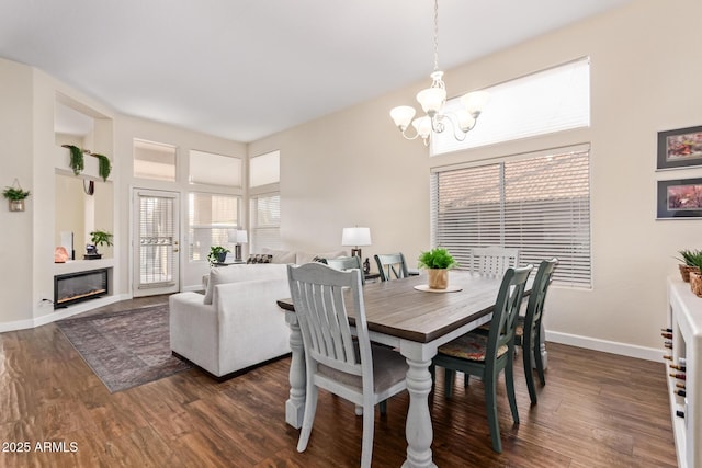 dining space with dark hardwood / wood-style floors and a chandelier