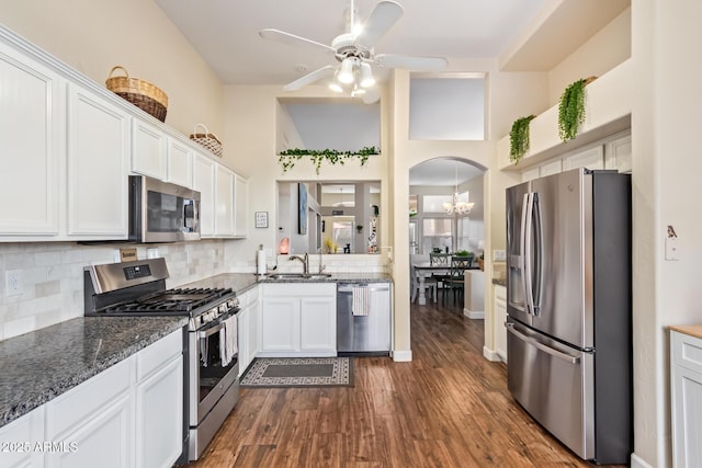 kitchen featuring appliances with stainless steel finishes, white cabinetry, sink, backsplash, and dark hardwood / wood-style flooring