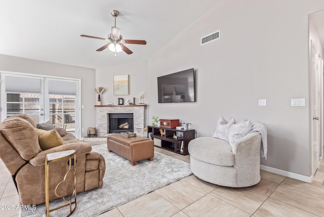 living room with a fireplace, lofted ceiling, light tile patterned floors, ceiling fan, and french doors