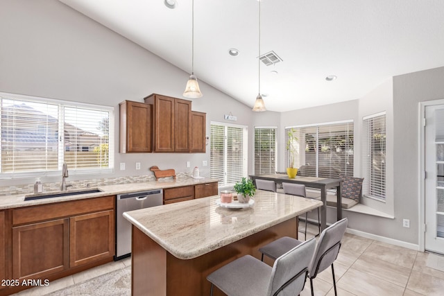 kitchen featuring sink, a breakfast bar area, a center island, dishwasher, and pendant lighting