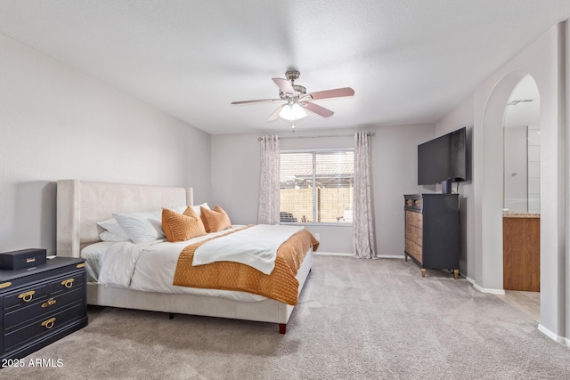 bedroom featuring ceiling fan, connected bathroom, and light carpet