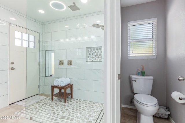 bathroom featuring toilet and a tile shower