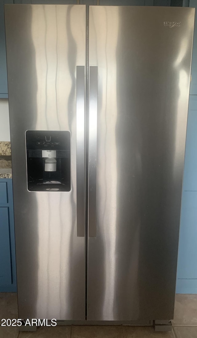 interior details featuring blue cabinetry and stainless steel fridge