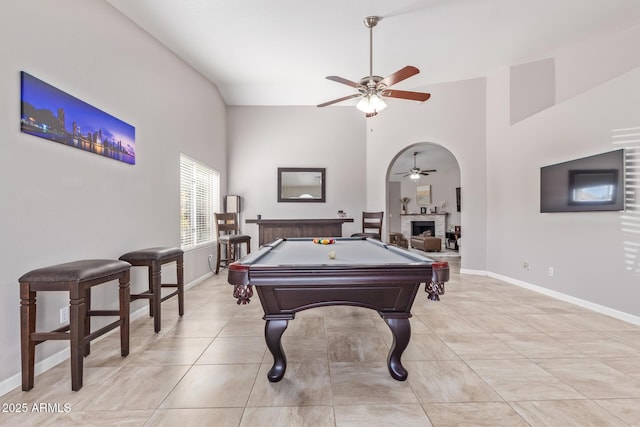 rec room featuring a brick fireplace, a towering ceiling, billiards, and ceiling fan