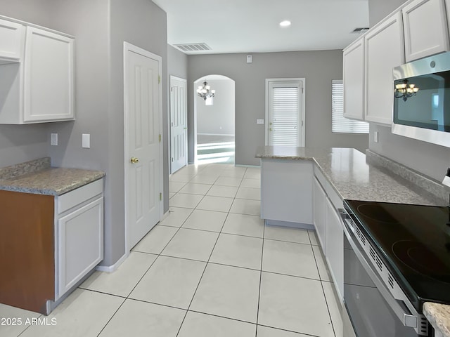 kitchen featuring light tile patterned floors, white cabinets, and appliances with stainless steel finishes