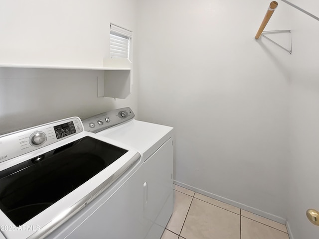 clothes washing area featuring light tile patterned flooring and washer and dryer