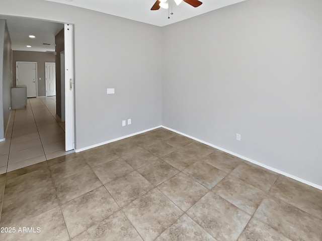 empty room with ceiling fan and light tile patterned flooring