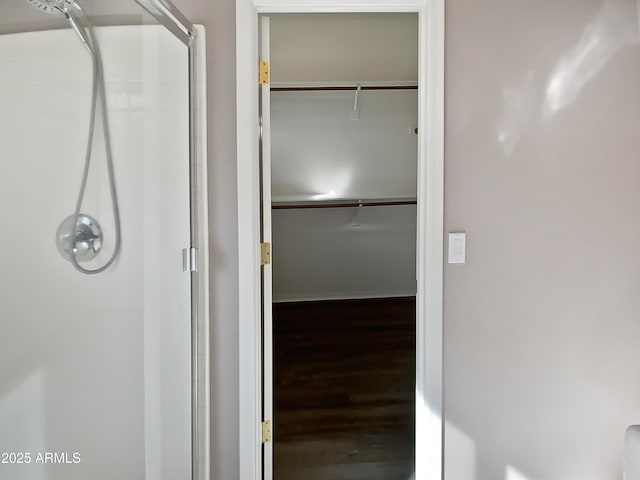 bathroom with hardwood / wood-style flooring and walk in shower