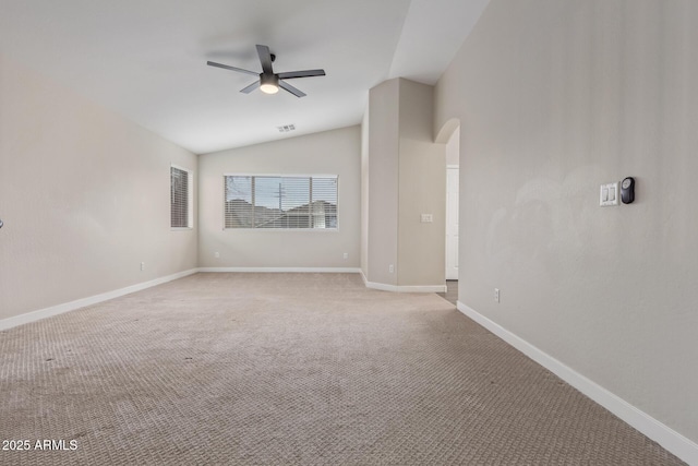 unfurnished room featuring arched walkways, light carpet, vaulted ceiling, ceiling fan, and baseboards