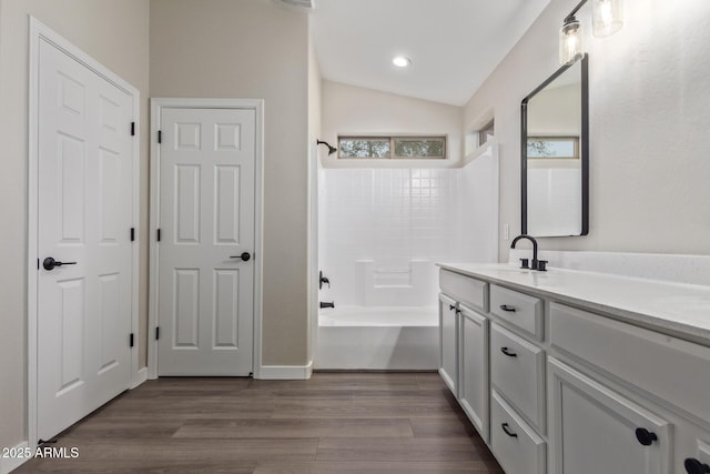 full bath featuring lofted ceiling, tub / shower combination, wood finished floors, and vanity