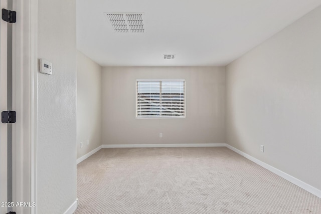 carpeted spare room with visible vents and baseboards