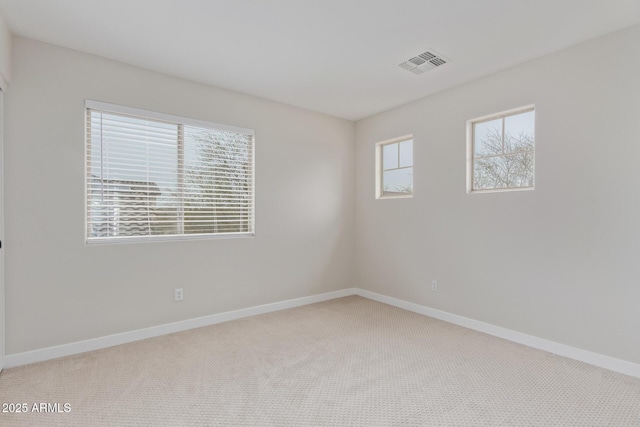 empty room with baseboards, visible vents, and carpet flooring