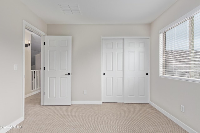 unfurnished bedroom with a closet, visible vents, baseboards, and carpet flooring