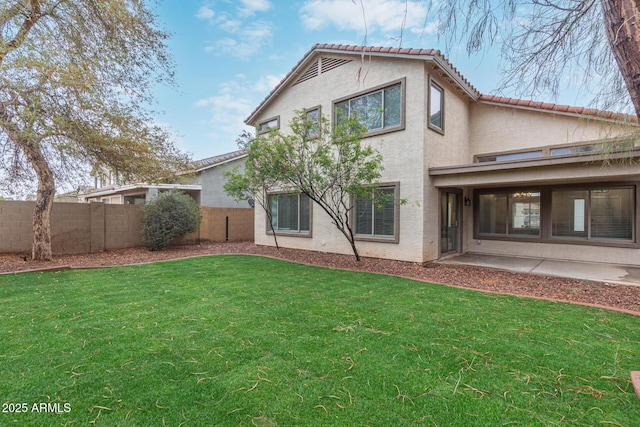 back of house with a yard, a patio, stucco siding, fence, and a tiled roof