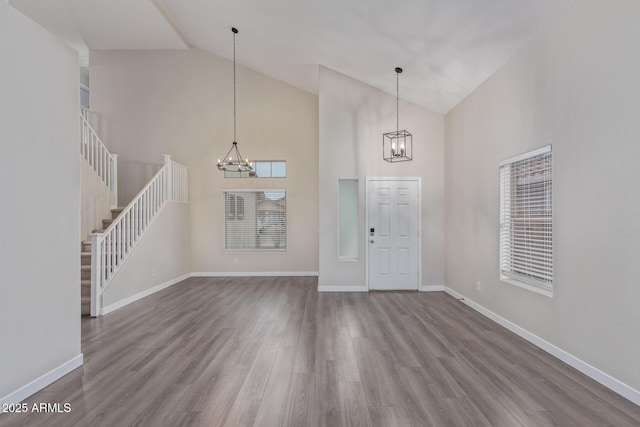 entryway with a notable chandelier, stairway, baseboards, and wood finished floors