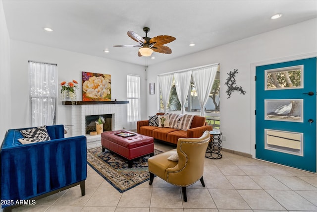 tiled living room featuring a fireplace, a wealth of natural light, and ceiling fan